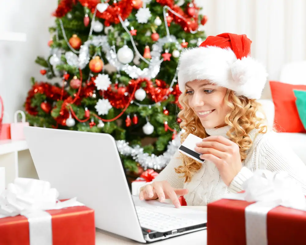 Uma pessoa sorrindo enquanto faz compras de presentes, aproveitando as Ofertas de Natal no conforto de casa.