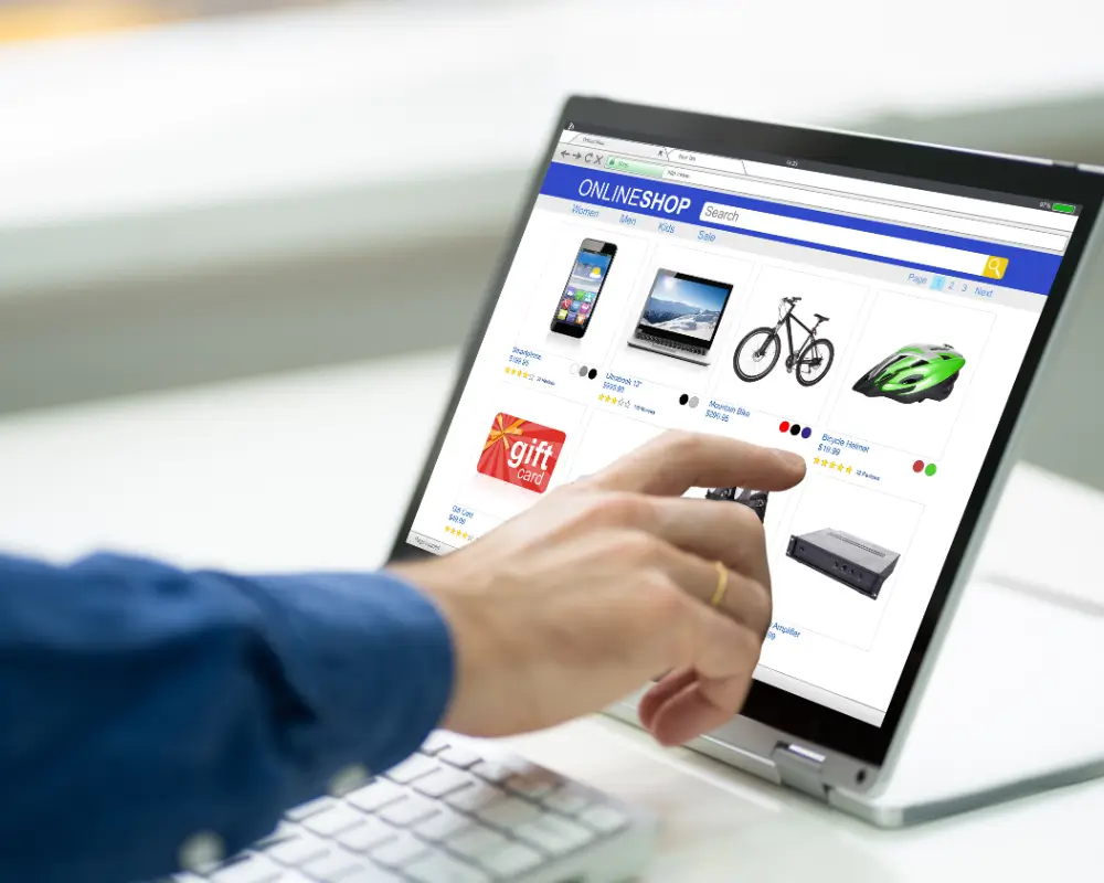 Pessoa sentada confortavelmente em um sofá fazendo compras online em um notebook durante o Dia do Consumidor.