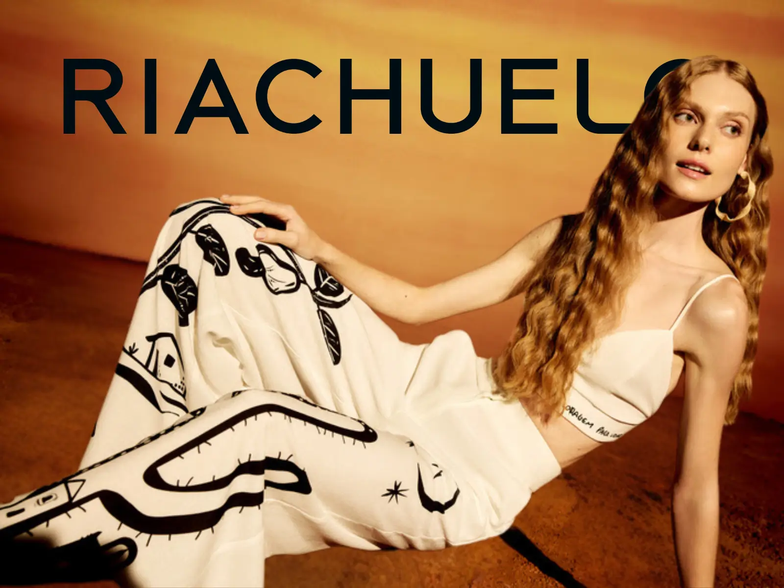 Modelo feminina vestindo um conjunto de calça e top estampado da nova coleção da Riachuelo, representando as tendências de moda que podem ser compradas com cupom.