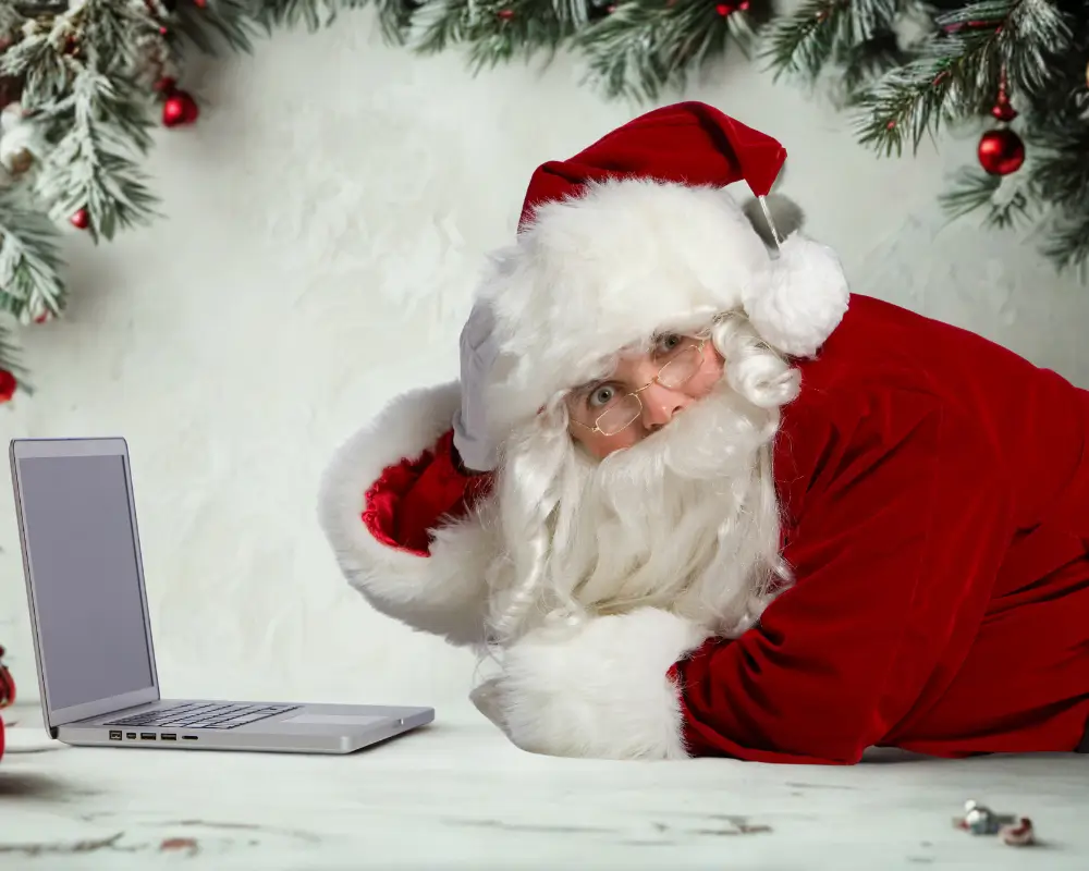 Papai Noel moderno, usando um notebook para descobrir as melhores Ofertas de Natal online.
