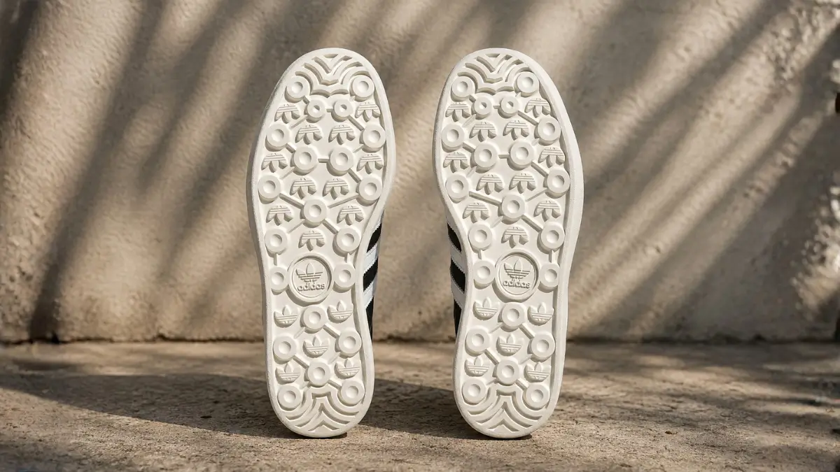 detalhe da sola de borracha do tenis adidas gazelle mostrando o padrao de logos da marca