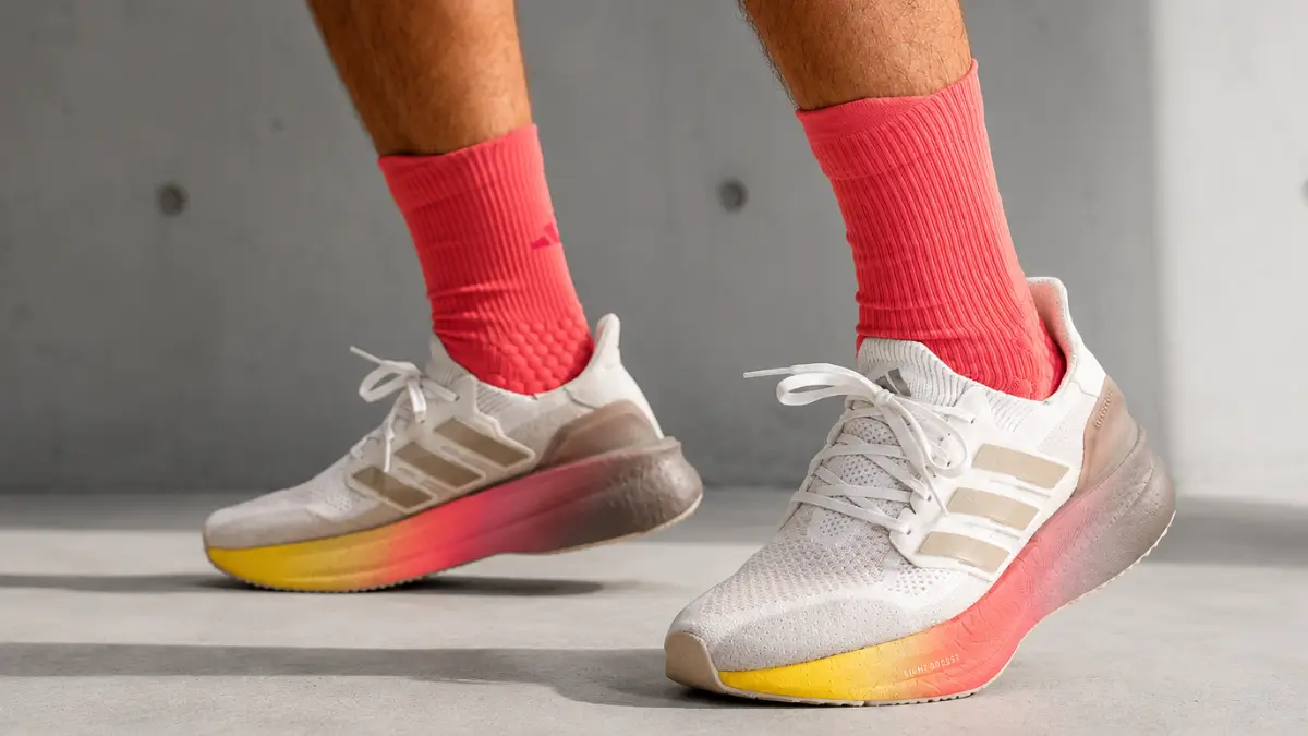 tenis adidas ultraboost 5 no pe de um corredor destacando o ajuste do cabedal primeknit