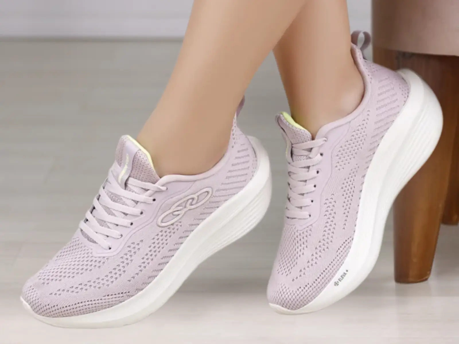 Tênis casual feminino da Olympikus na cor lilás com solado branco, nos pés de uma mulher, destacando o estilo moderno da linha casual em promoção.